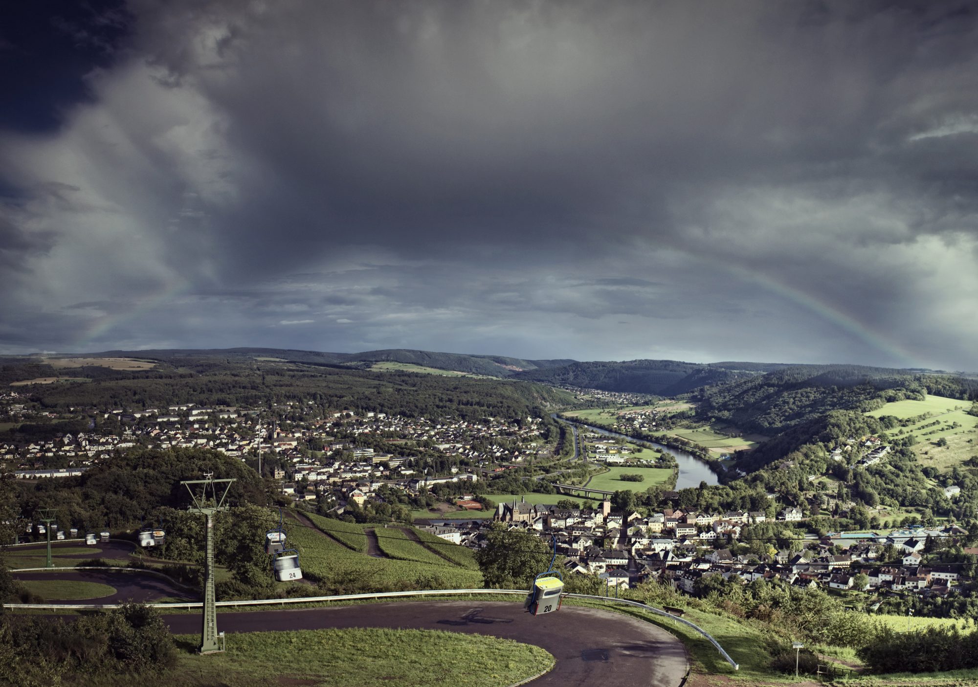 Panormaansicht von Saarburg vom Warsberg, im Vordergrund Sesselbahn, Im Hintergrund Stadtüberblick, Wolkenverhangen