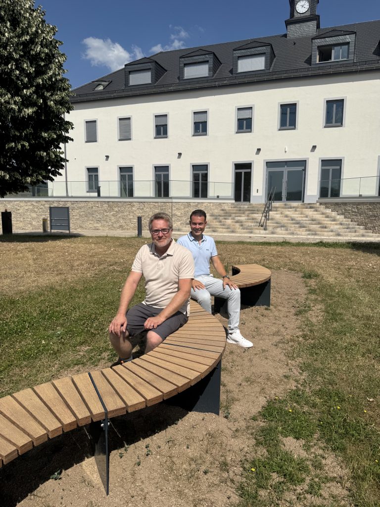 Andreas Reymann und Alexander Burger auf der neuen schlangenförmigen Bank.
